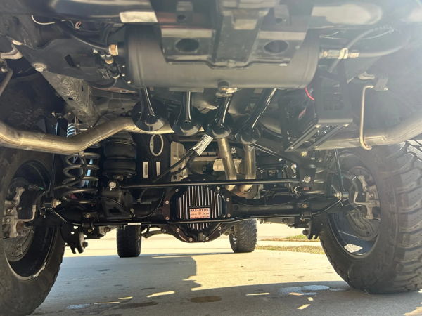 Close-up of train horn kit with air tank mounted above Mag-Hytec differential on lifted Ram