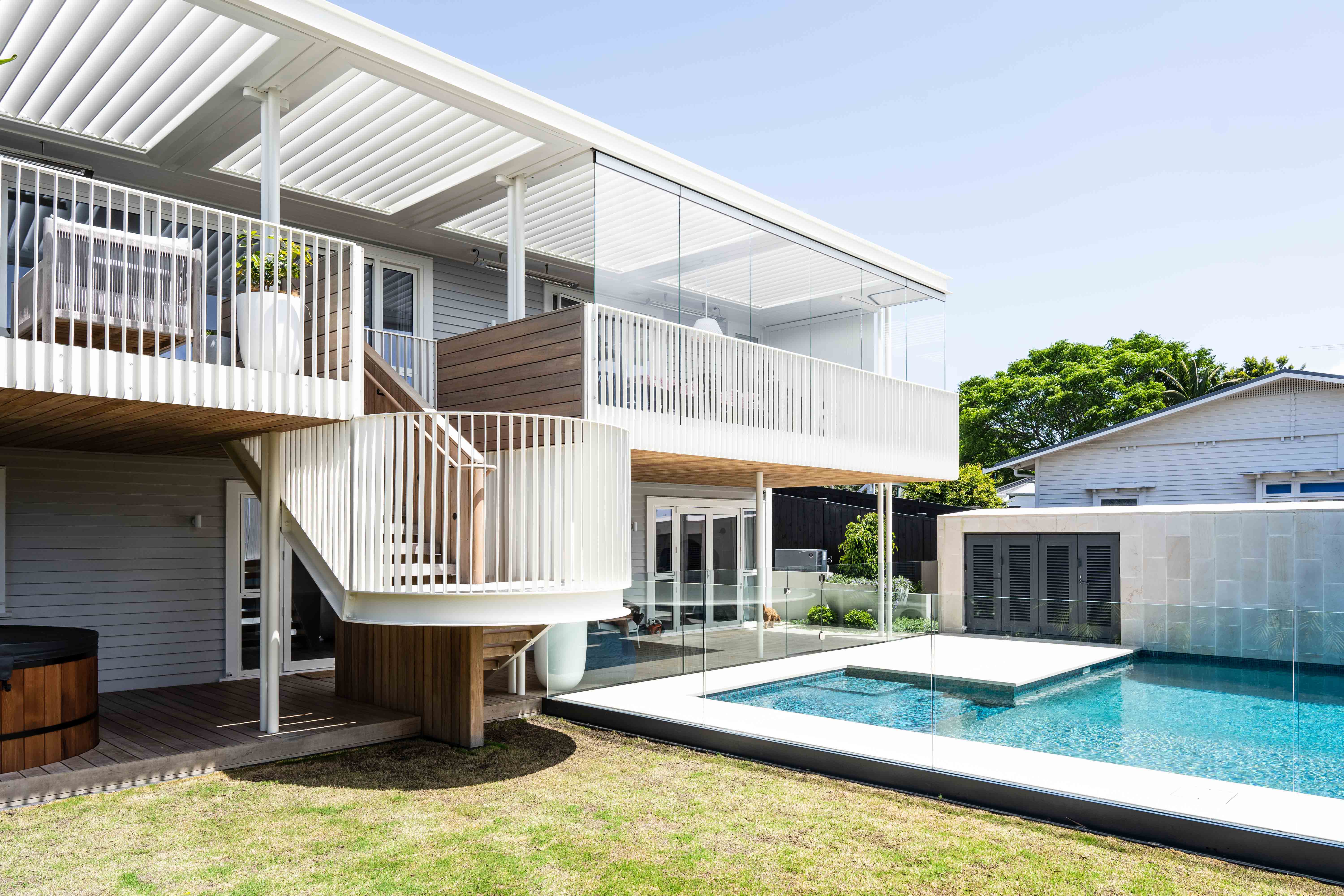 Modern house exterior with pool and landscaped yard.