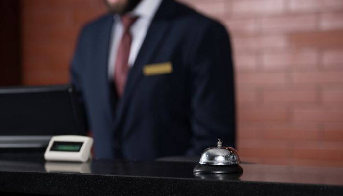 Hotel clerk wearing suit and tie at lobby desk