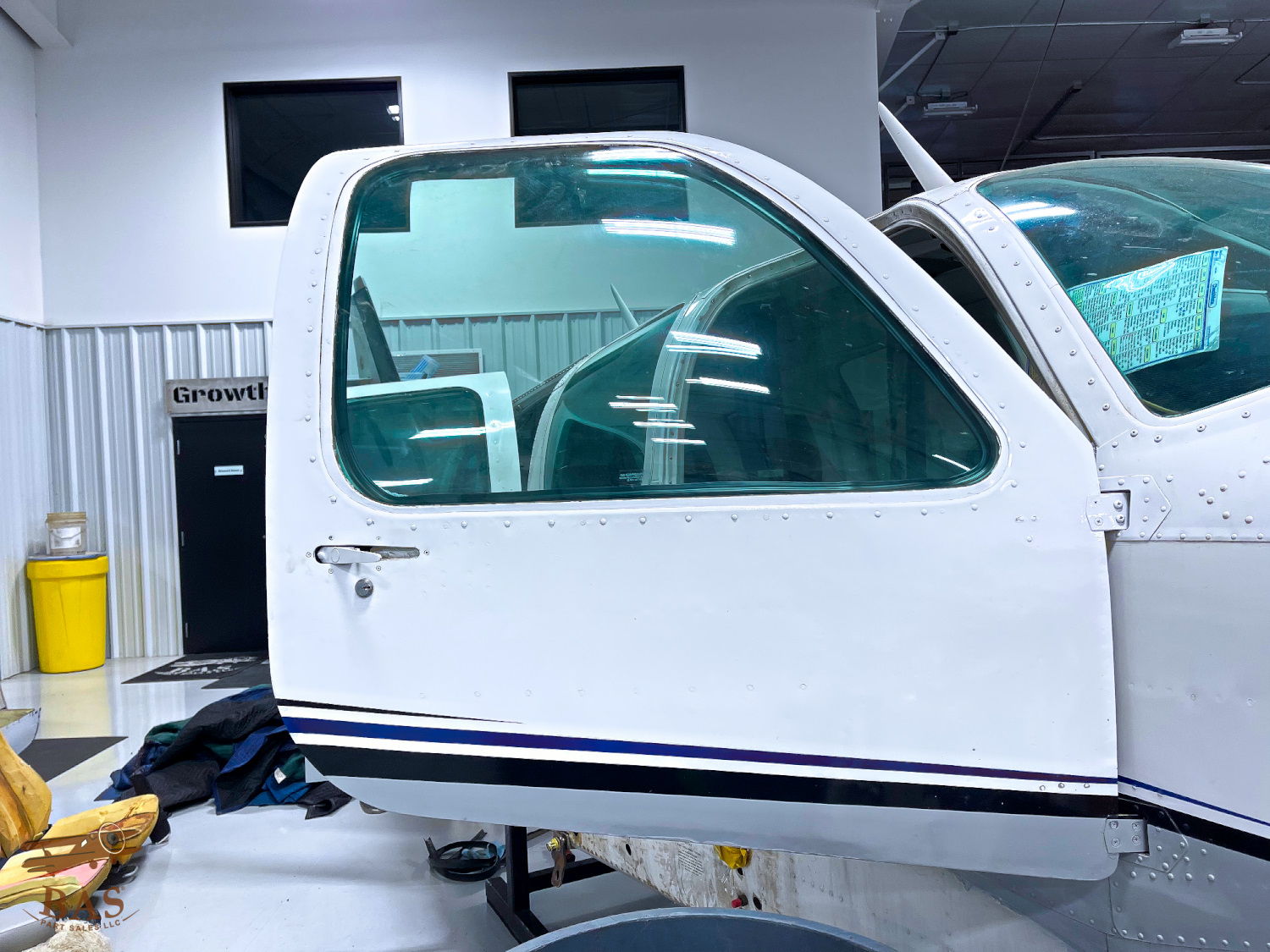 White airplane door with a clear window in a hangar setting.