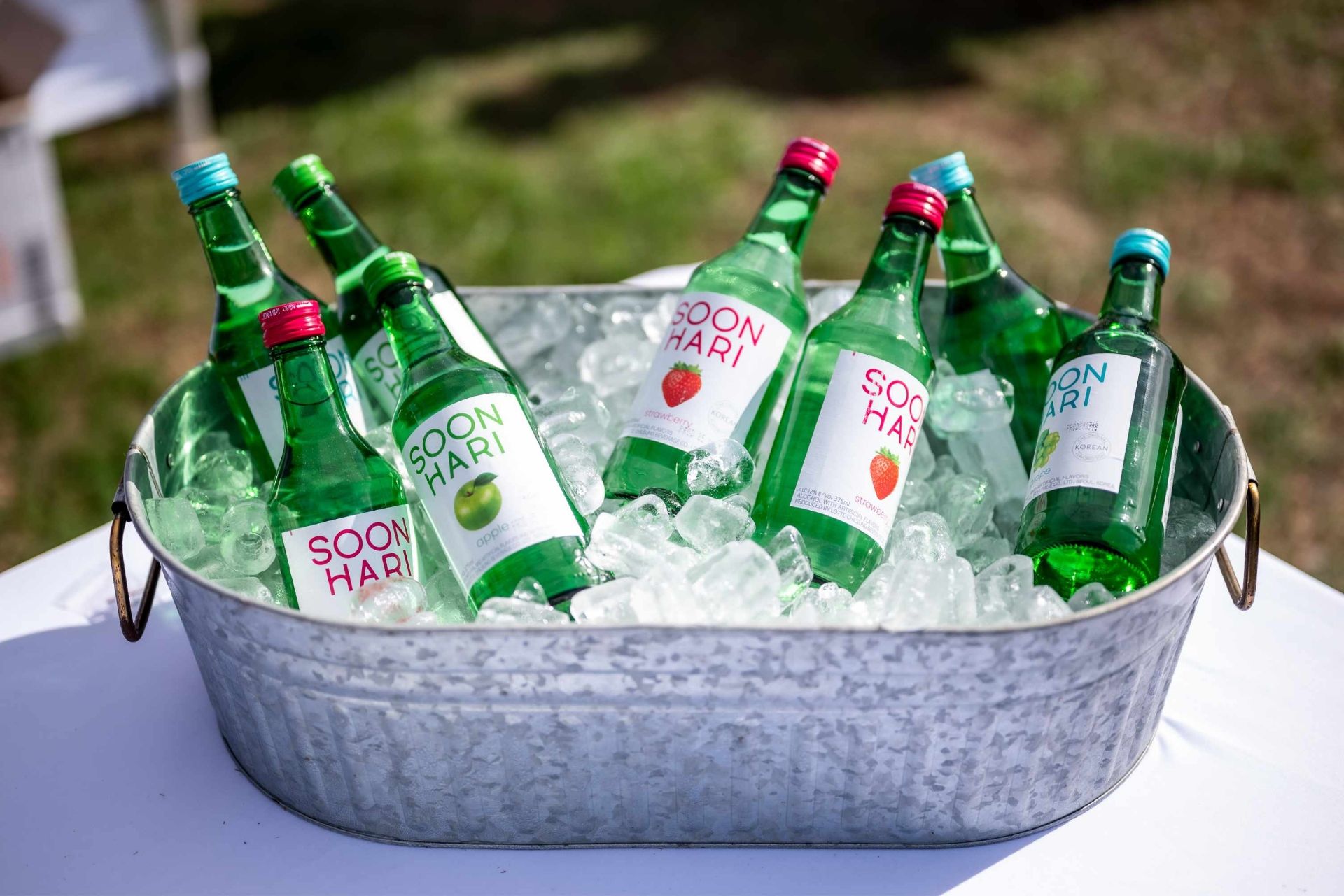 Green bottled drinks in a metal tub filled with ice.