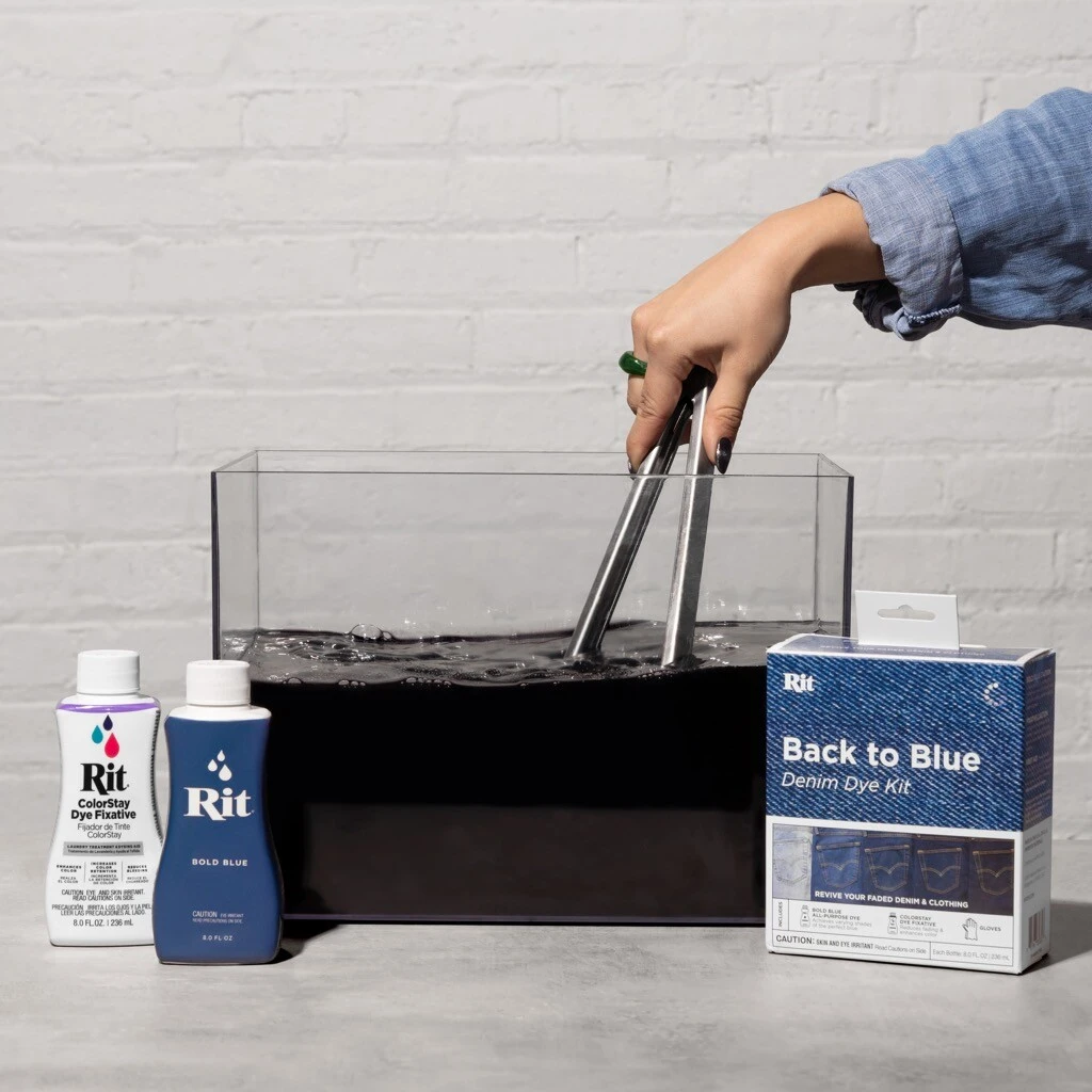 Hand using tongs in a tank with dye and fabric dye products.