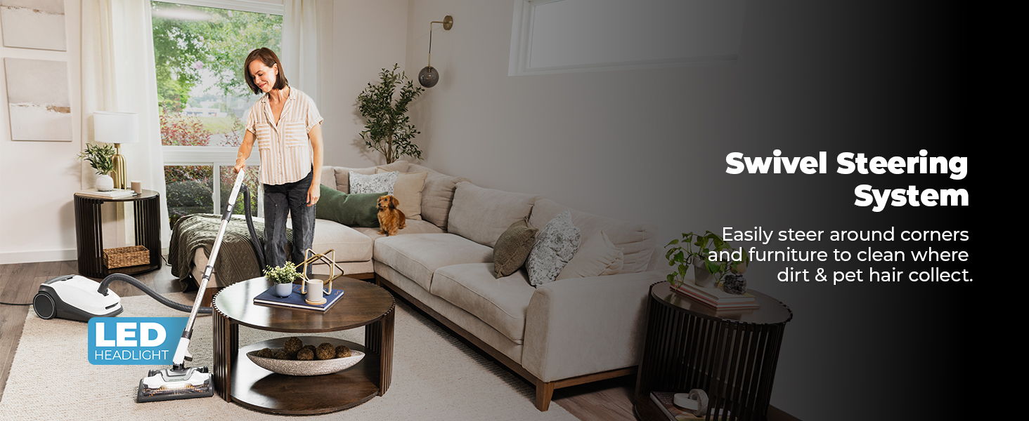 Woman vacuuming a living room with a swivel steering system.