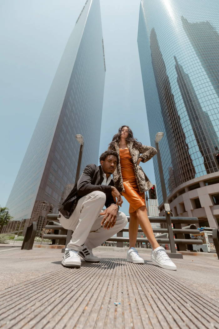 male and female model wearing adidas forum shoes in city