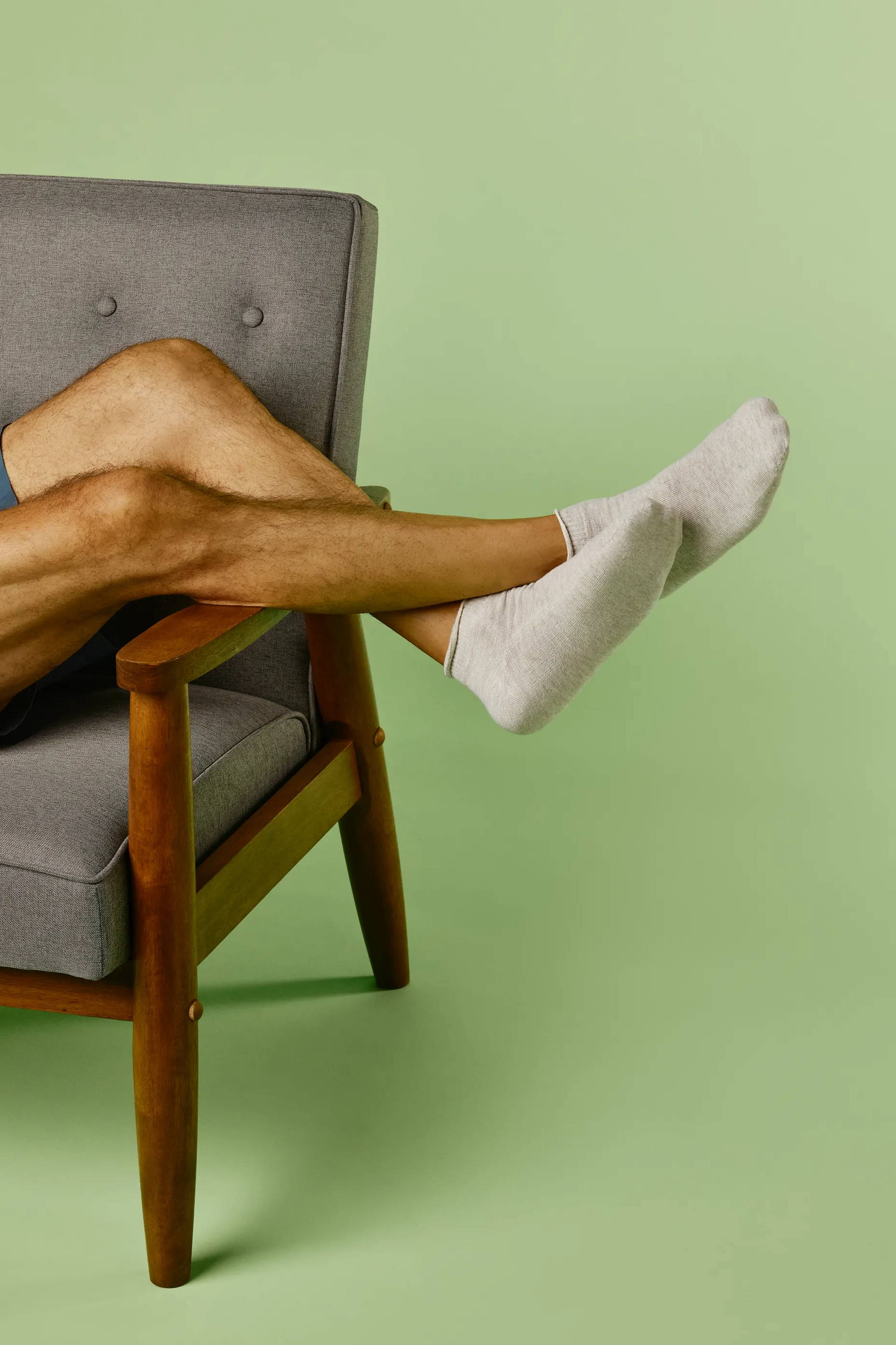 Man leaning in chair wearing SmartKnit Mini Crew Seamless Socks