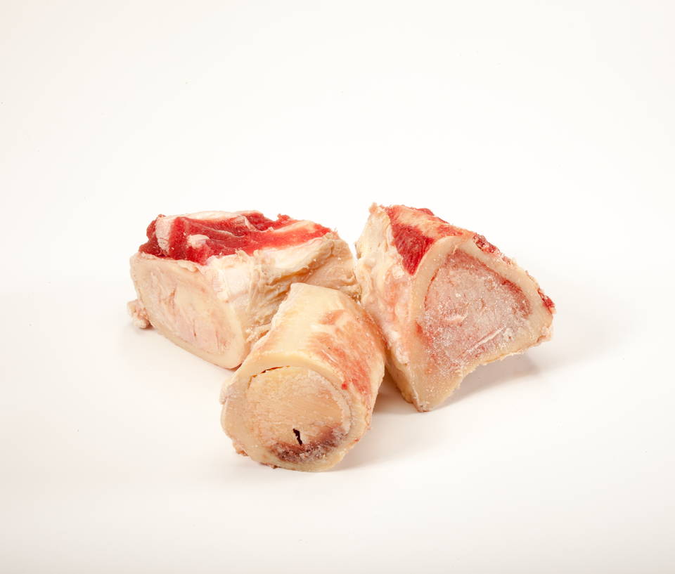 Three raw beef marrow bones with white background.