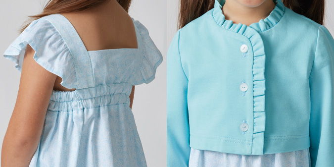 Girl wearing a light blue dress with ruffled sleeves and a matching jacket.