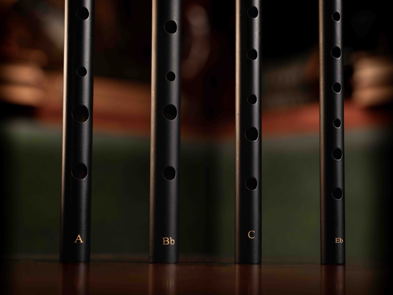 Four Wild Irish Whistles lined up on a wooden surface.