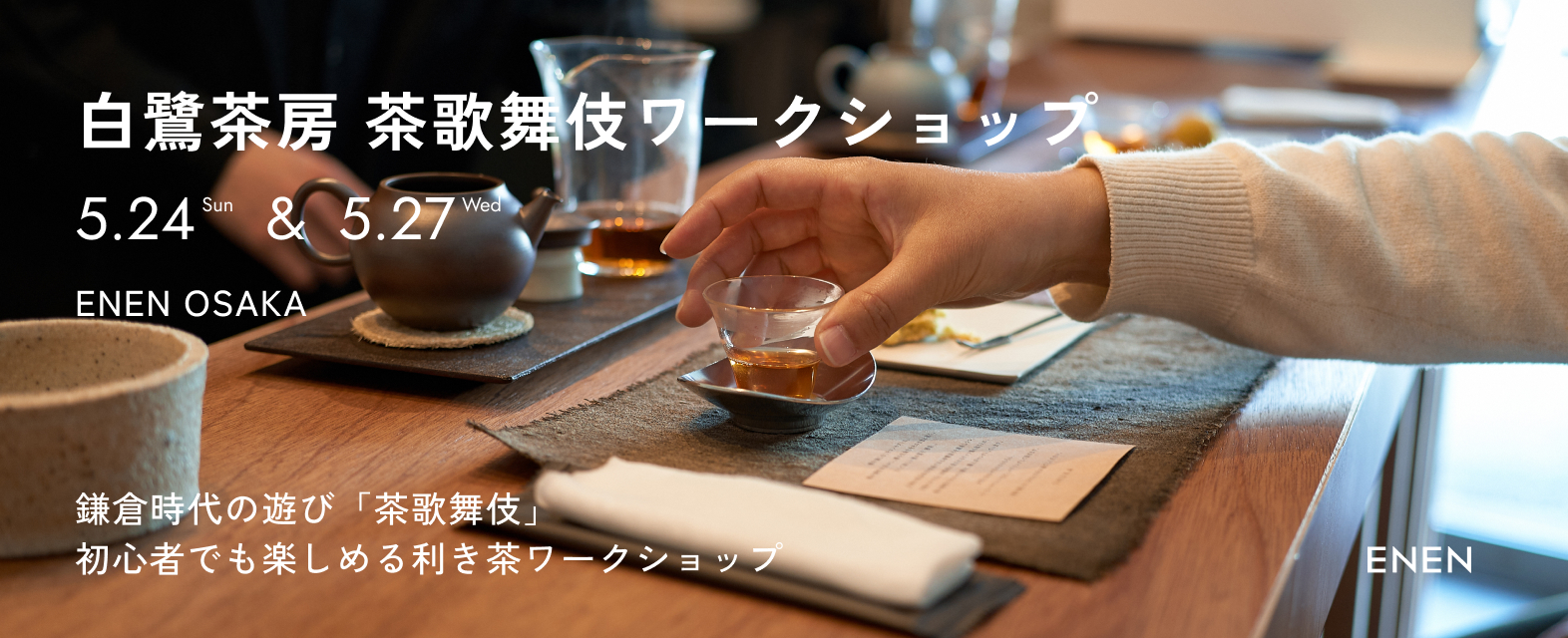 Tea workshop promotion with cups and tea utensils on a wooden table.