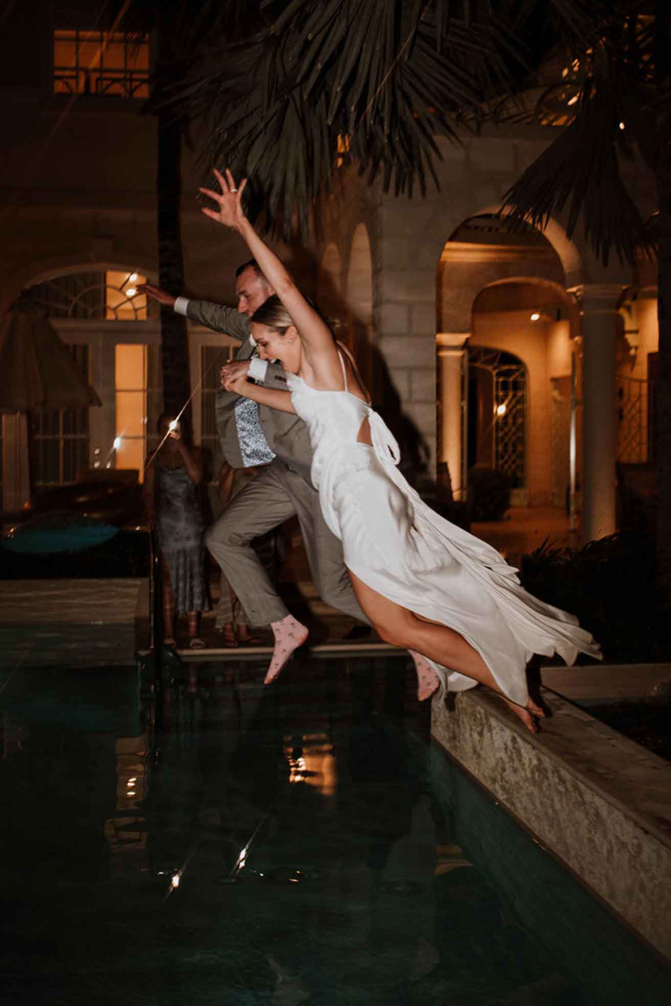 Bride and Groom jumping into pool