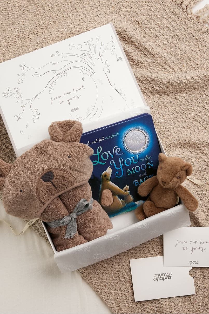 A gift box with a book and teddy bear toys.