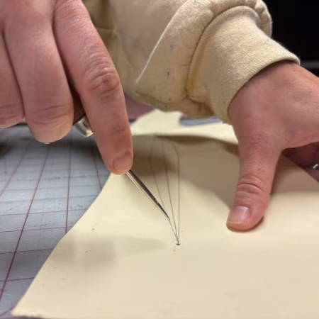 Using a awl to poke a hole in a pattern piece
