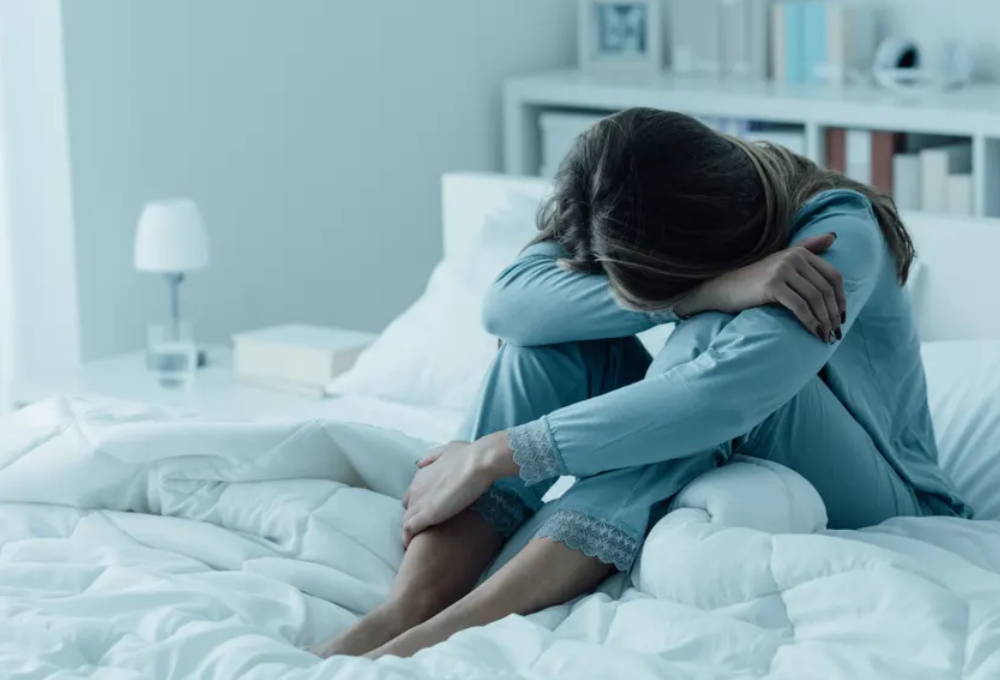 depressed woman in bed The gut-brain connection: how gut health affects your mood