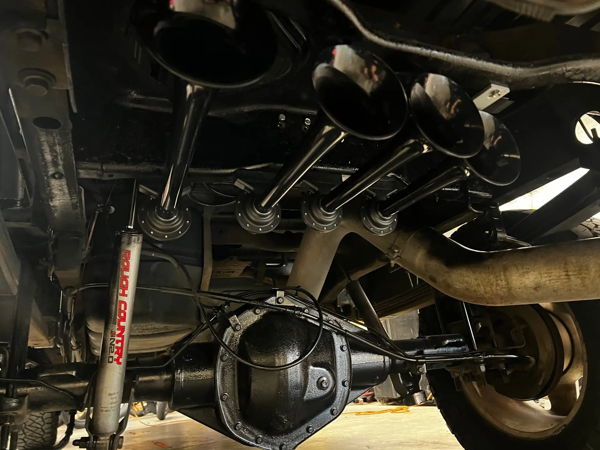 Underside view of train horn bells mounted near the rear axle on Kevin's 2007 Chevy Silverado Classic 2500HD, install photo 5