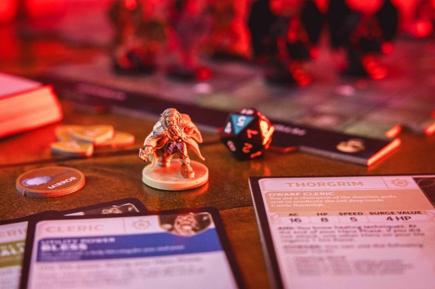 Tabletop gaming setup with miniatures, dice, and character sheets.