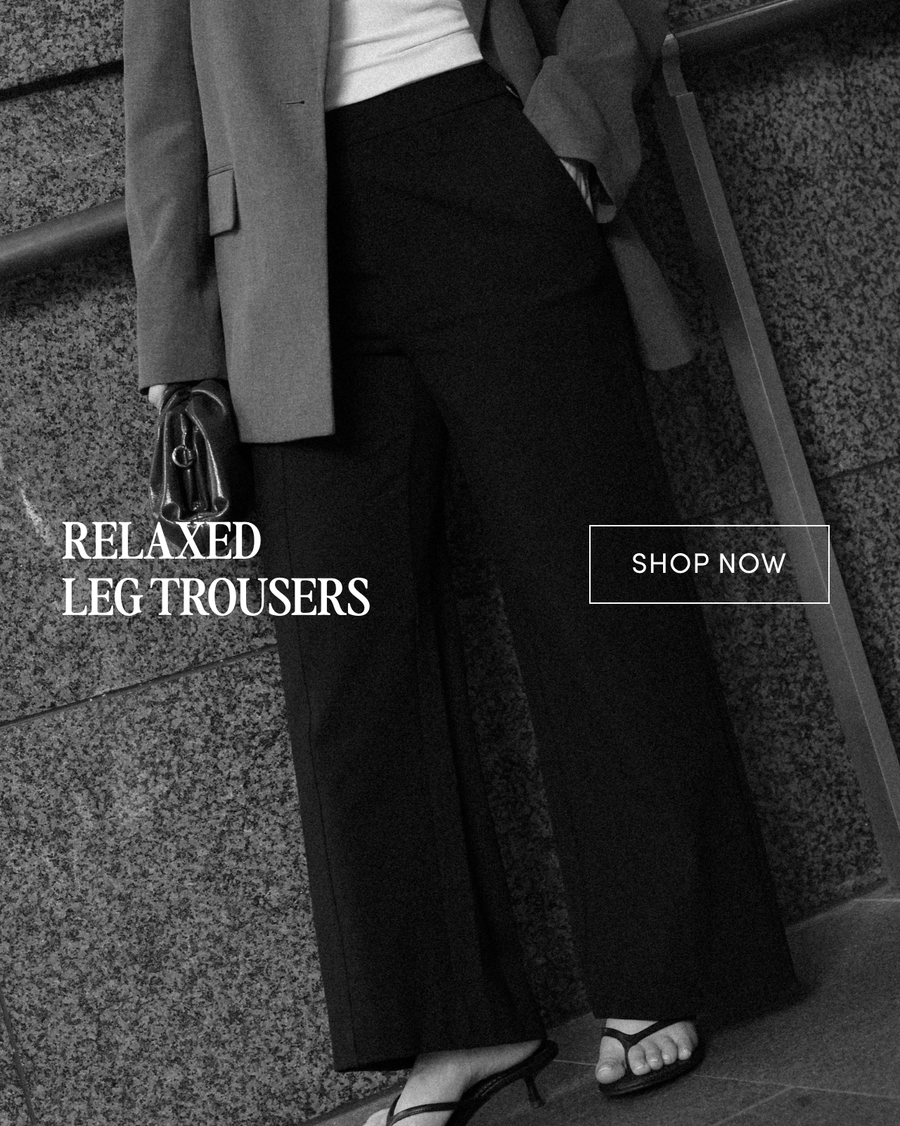 Woman wearing relaxed leg trousers against a textured background.