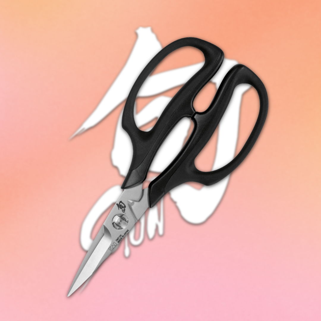 A pair of black-handled scissors on a gradient orange background.