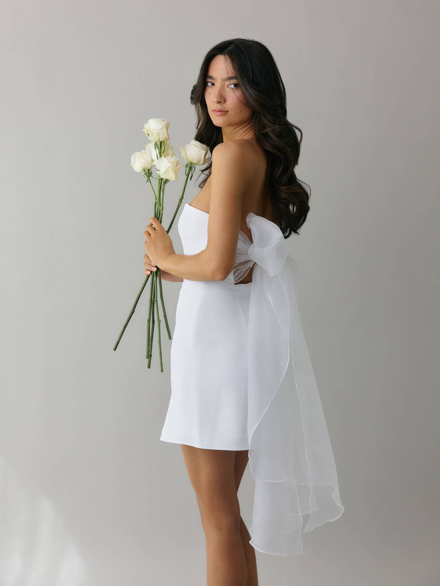 Girl wearing midi bridal event dress with crepe fabric and organza bow tie straps