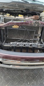 Front-mounted train horn manifold with four black trumpets installed behind the grille of a Dodge Ram 1500