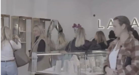 People shopping in a store with displays of jewelry and accessories.