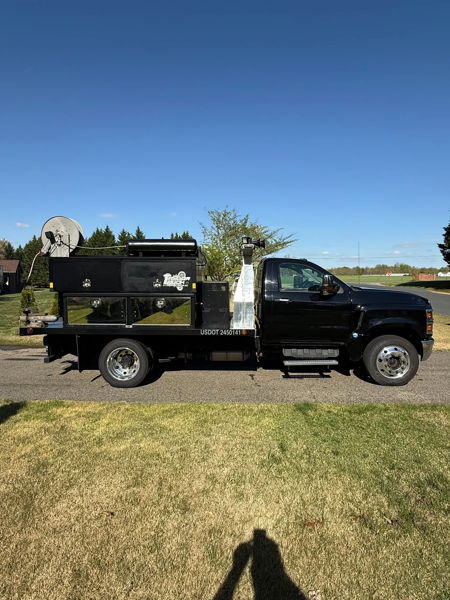 Full driver-side profile of Glenn's black 2020 Chevy Silverado 6500HD work truck parked on grass, install photo 2