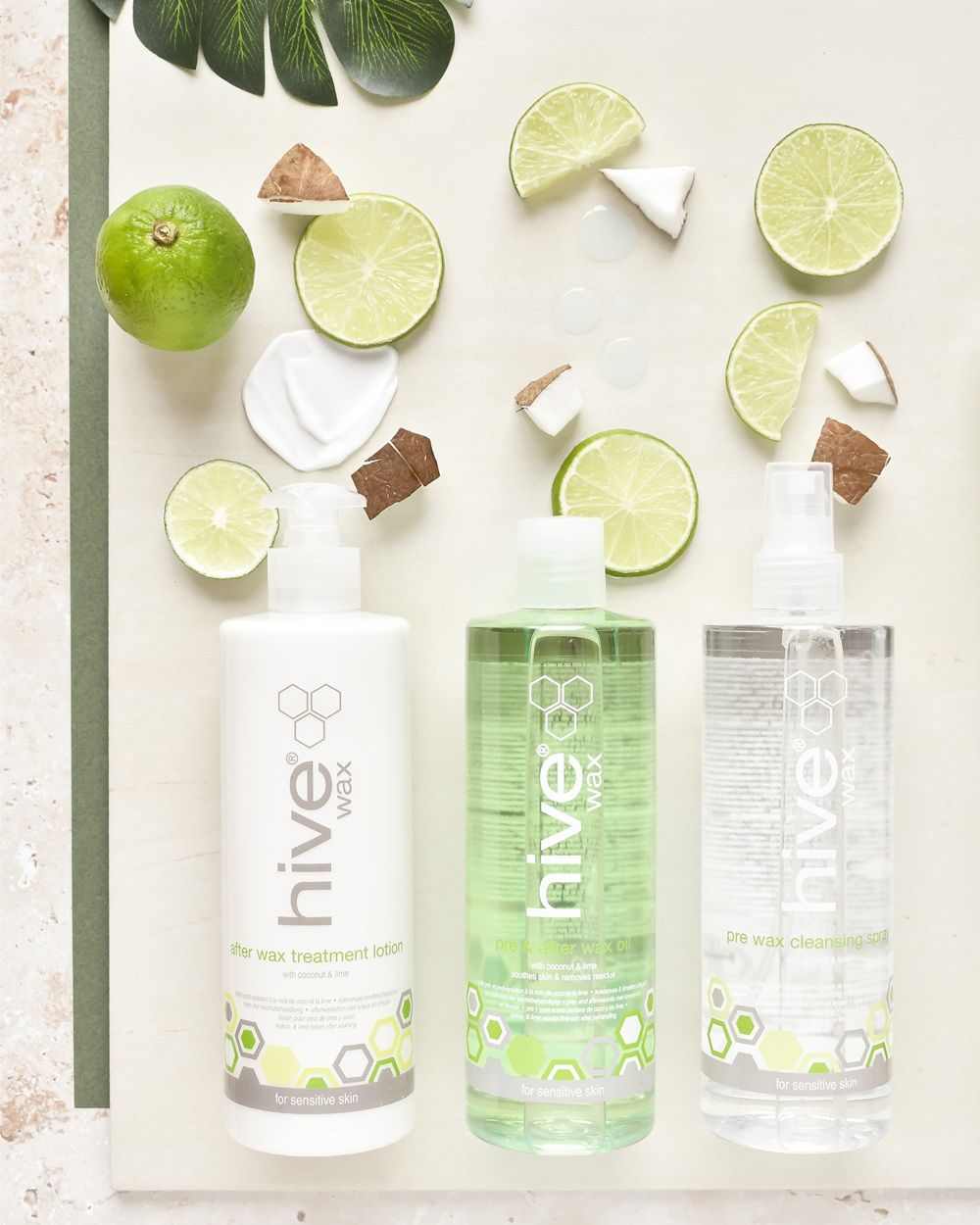 Three bottles of Hive88 products surrounded by lime and coconut slices.