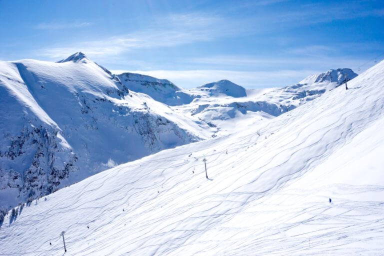Skiers enjoy the sunshine on the ski slopes.
