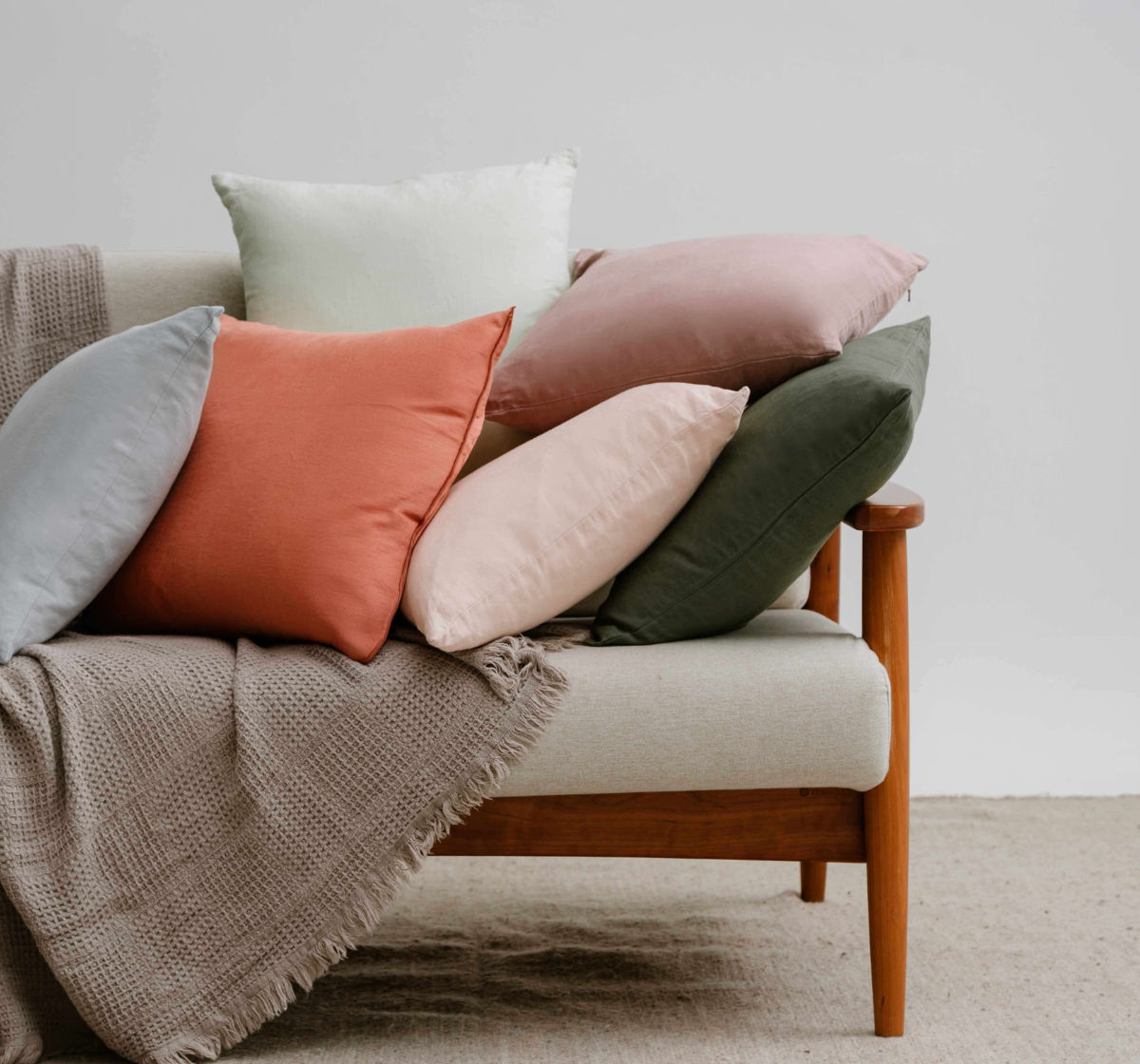 Colorful French linen cushions on a beige sofa 
