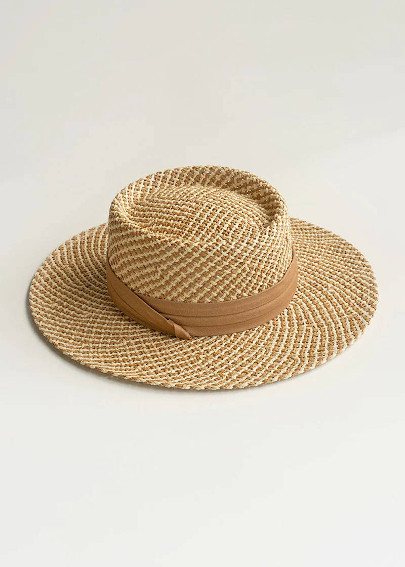 A straw brimmed hat with a complimenting beige ribbon detail