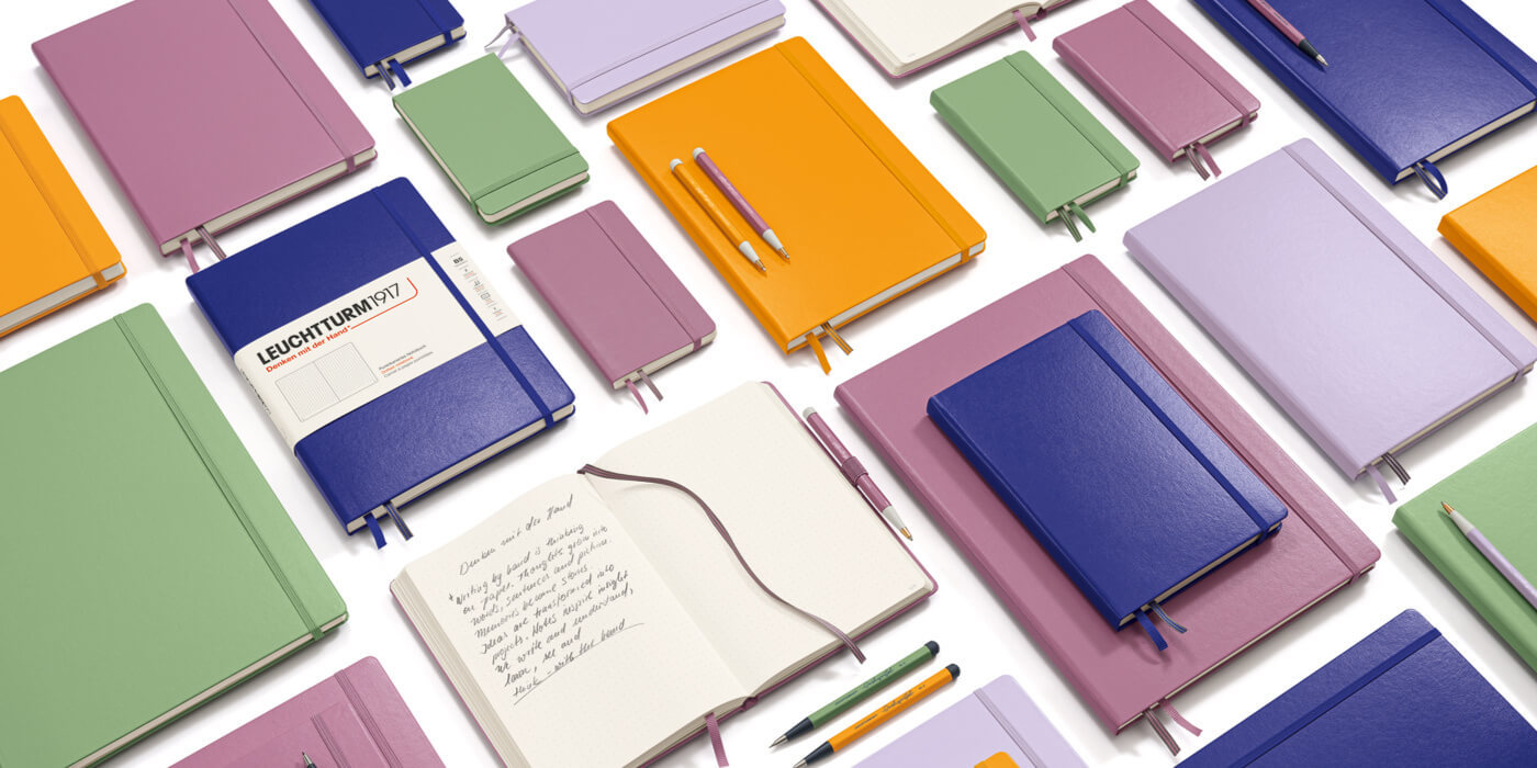 Colorful notebooks and journals arranged in a flat lay pattern.
