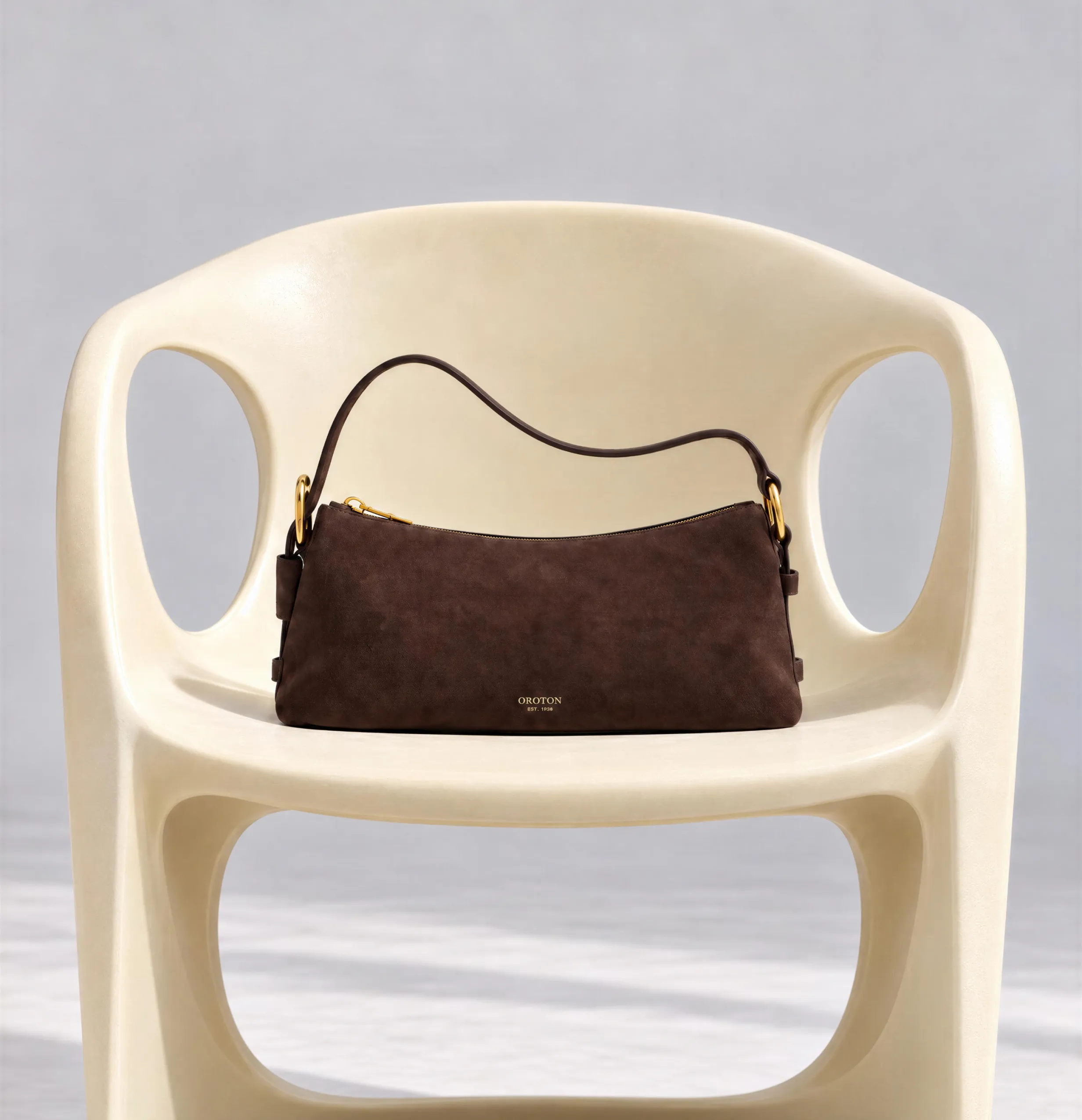 A brown bag resting on a light-colored plastic chair.