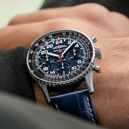 A close-up of a blue dial watch on a person's wrist.