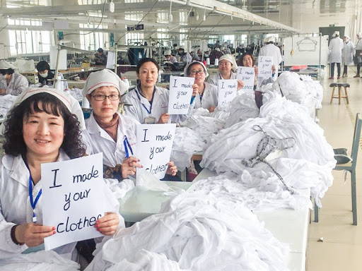 Hemp clothing manufacturing employees proudly hold signs saying “I made your clothes.”