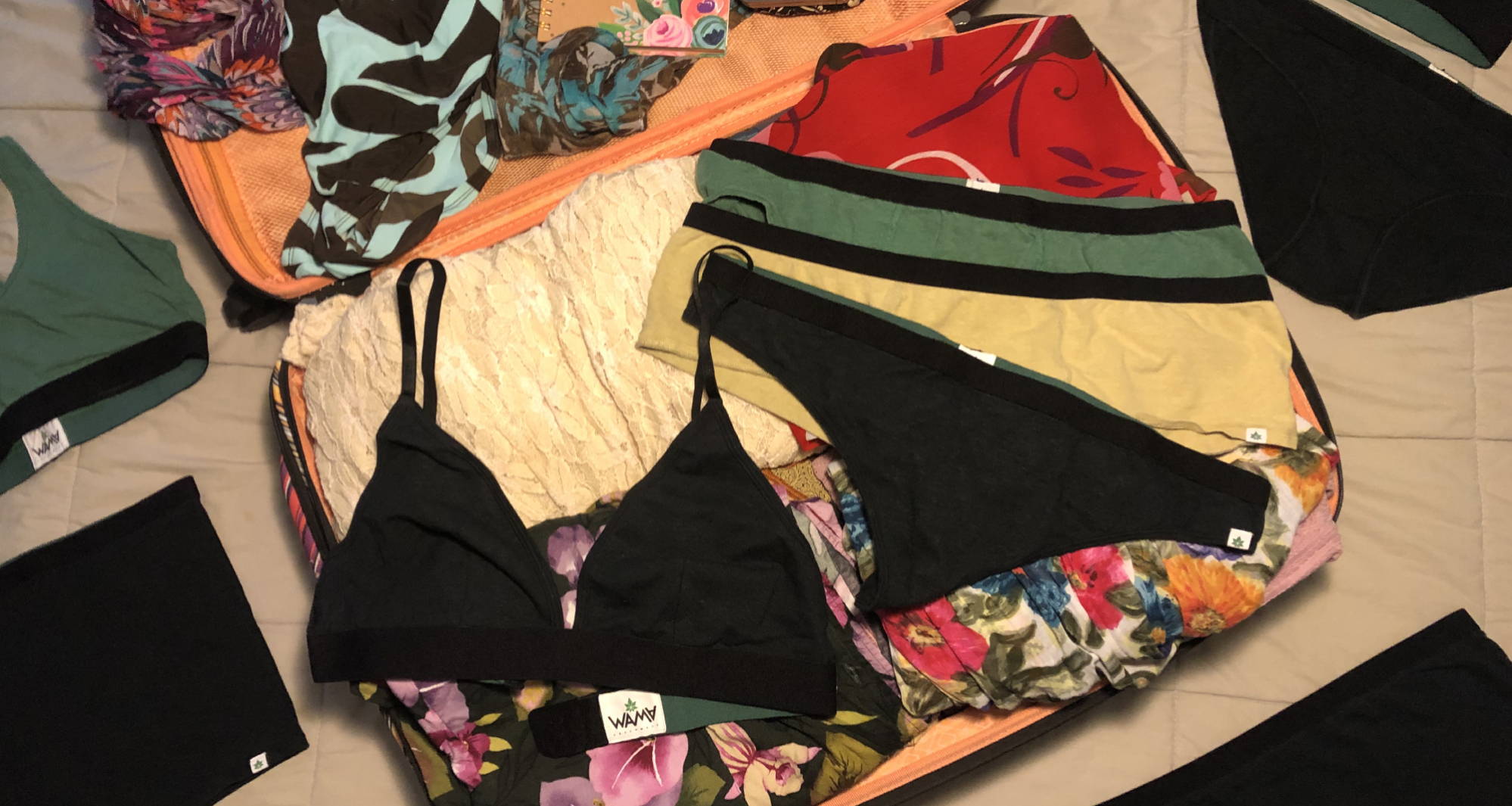 A suitcase filled with bright clothing and WAMA Underwear for a Florida Packing List.