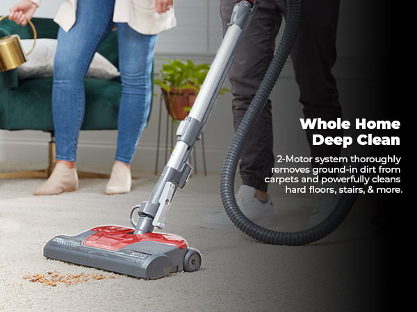 A person vacuuming a carpet with a vacuum cleaner.