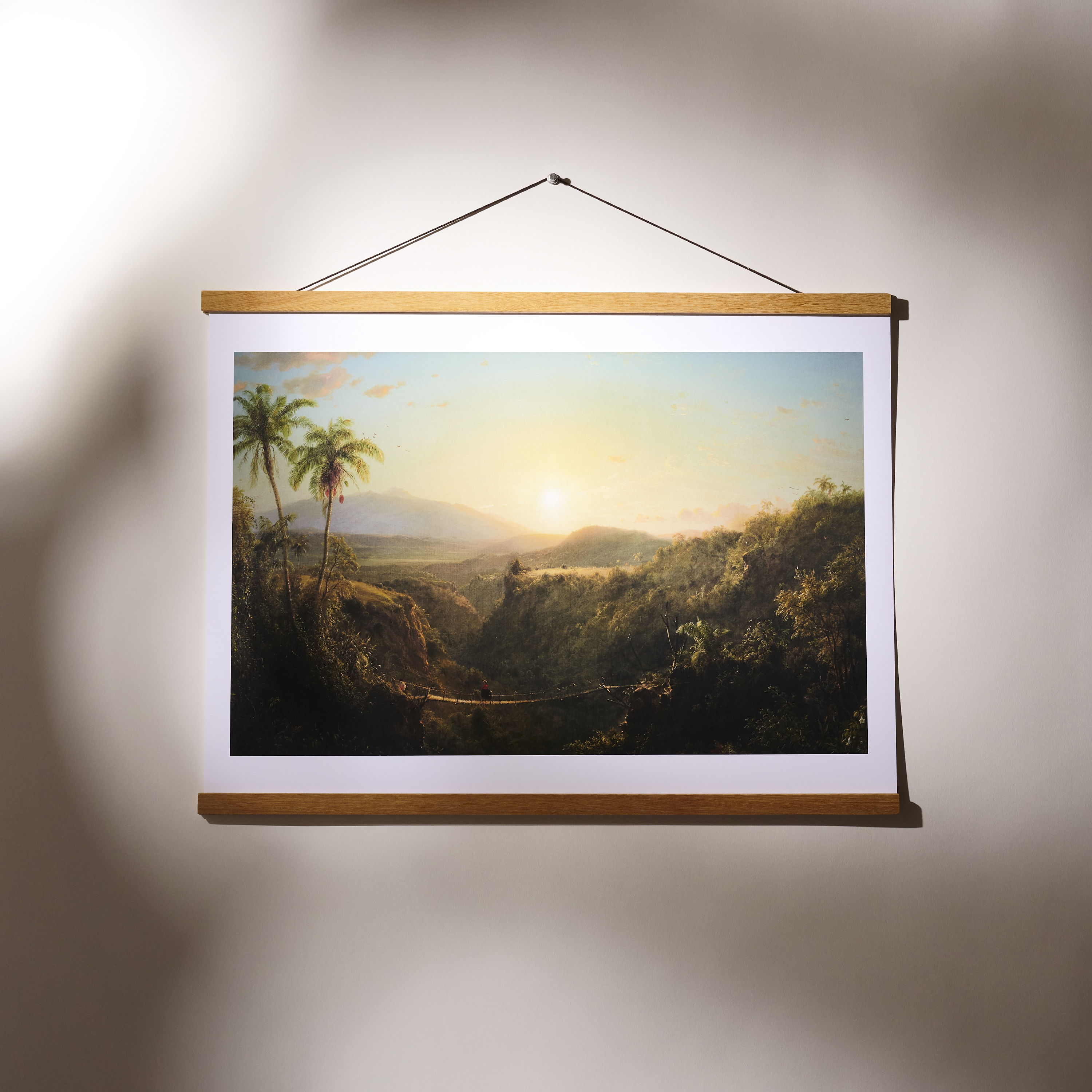 A framed landscape painting with mountains and a sunset.