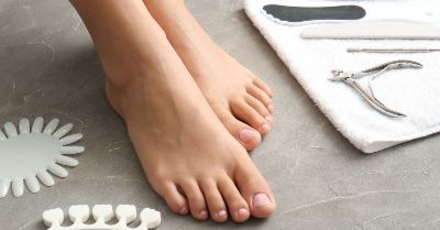 A pair of feet with pedicure tools nearby.