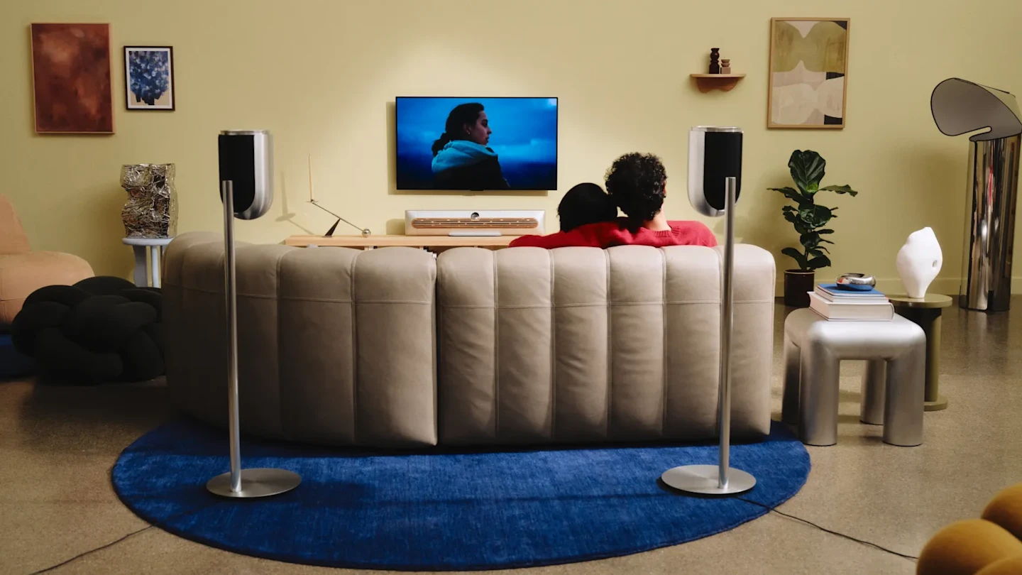 A couple watching TV on a couch in a cozy living room.