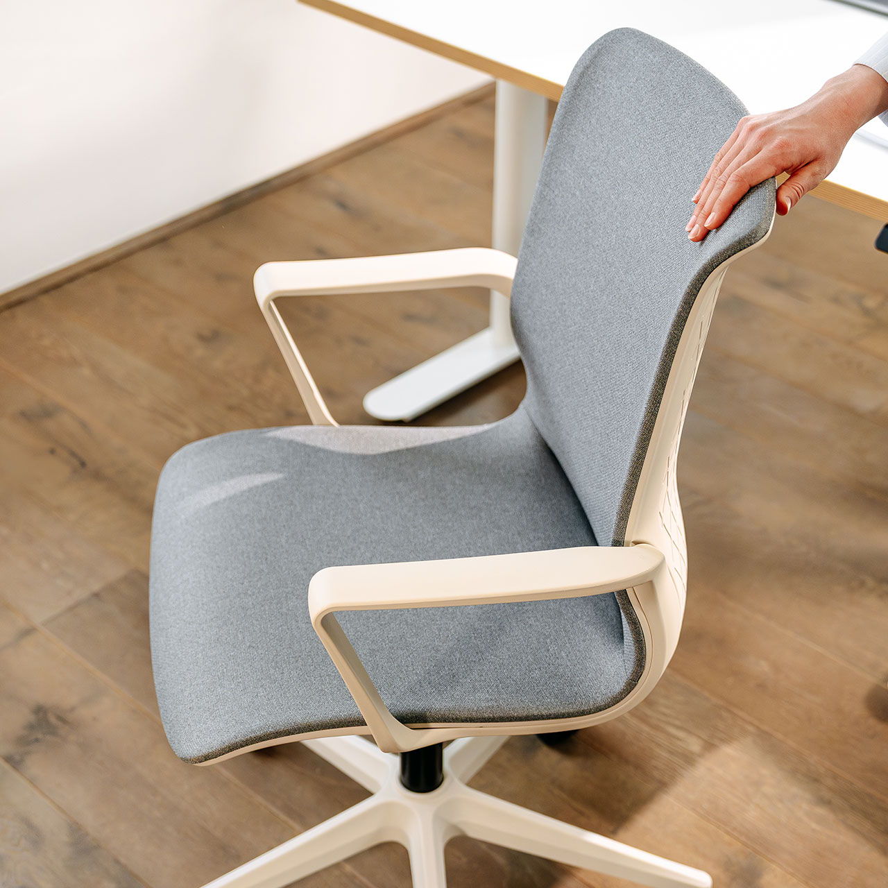 Vue de profil de la chaise de bureau blanche « Flex Office » de la marque ofinto dans un bureau à domicile moderne