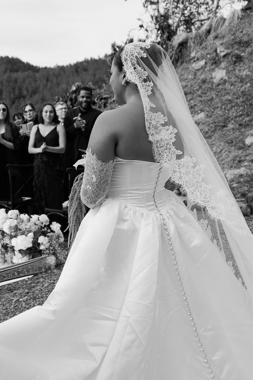 Bride in a wedding dress with guests in the background.