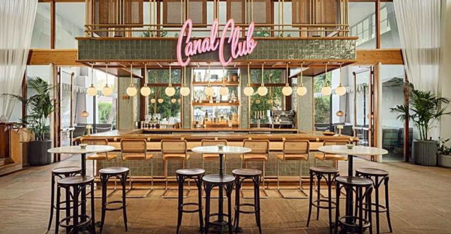 A stylish bar interior with wooden decor and neon signage.