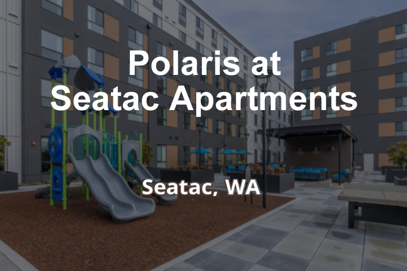 Playground with slides and seating area in a residential complex.