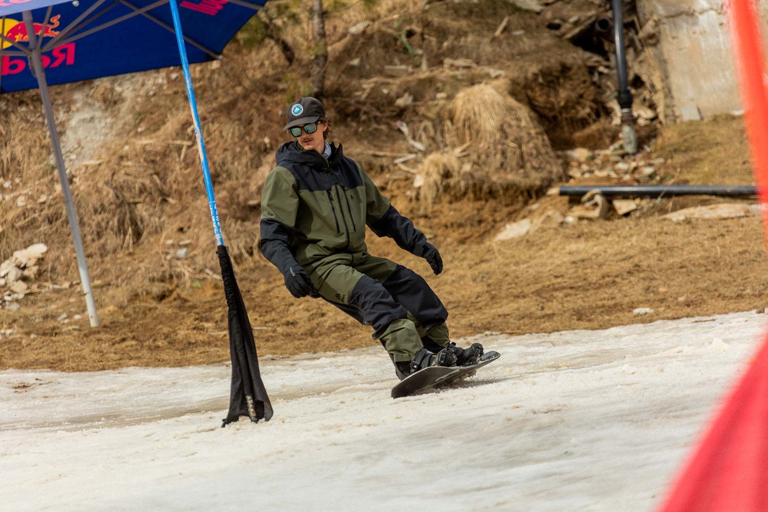 Person in gear snowboarding on a slope with a lift.