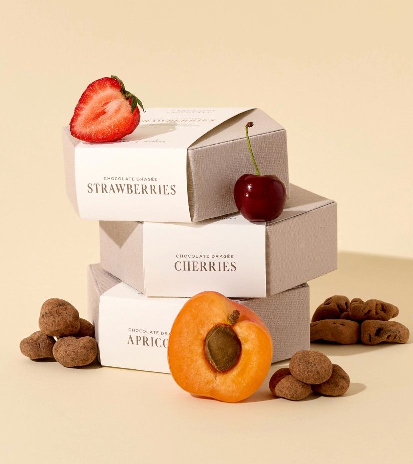Three boxes labeled with fruits and assorted nuts on a beige background.