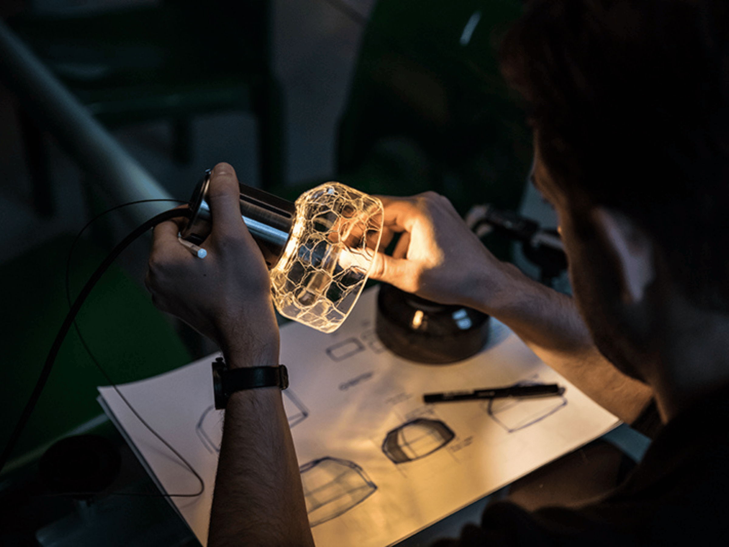 hands holding a crackle glass pendant by designer alex fitzpatrick