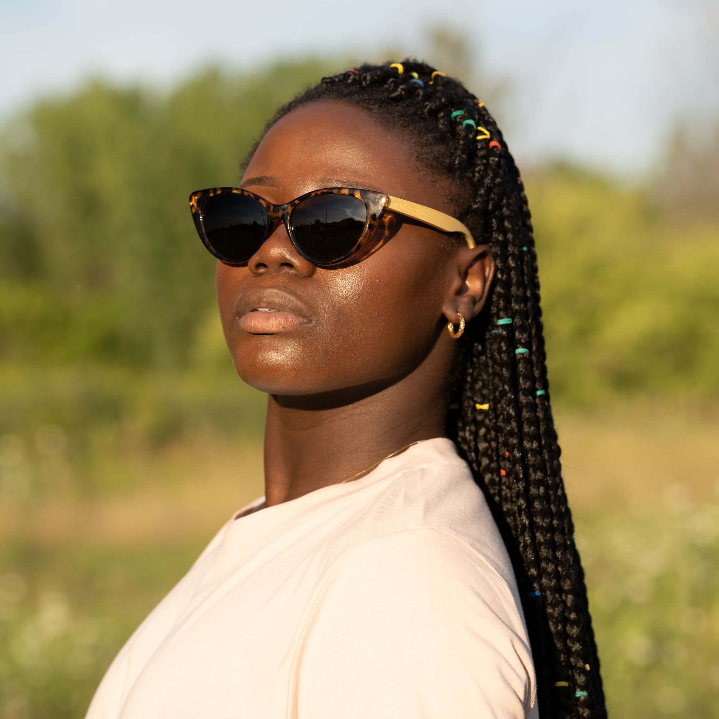 Femme au visage rond portant Stella, lunettes de soleil Cat-Eye Tortoise en bois de bambou bicolores