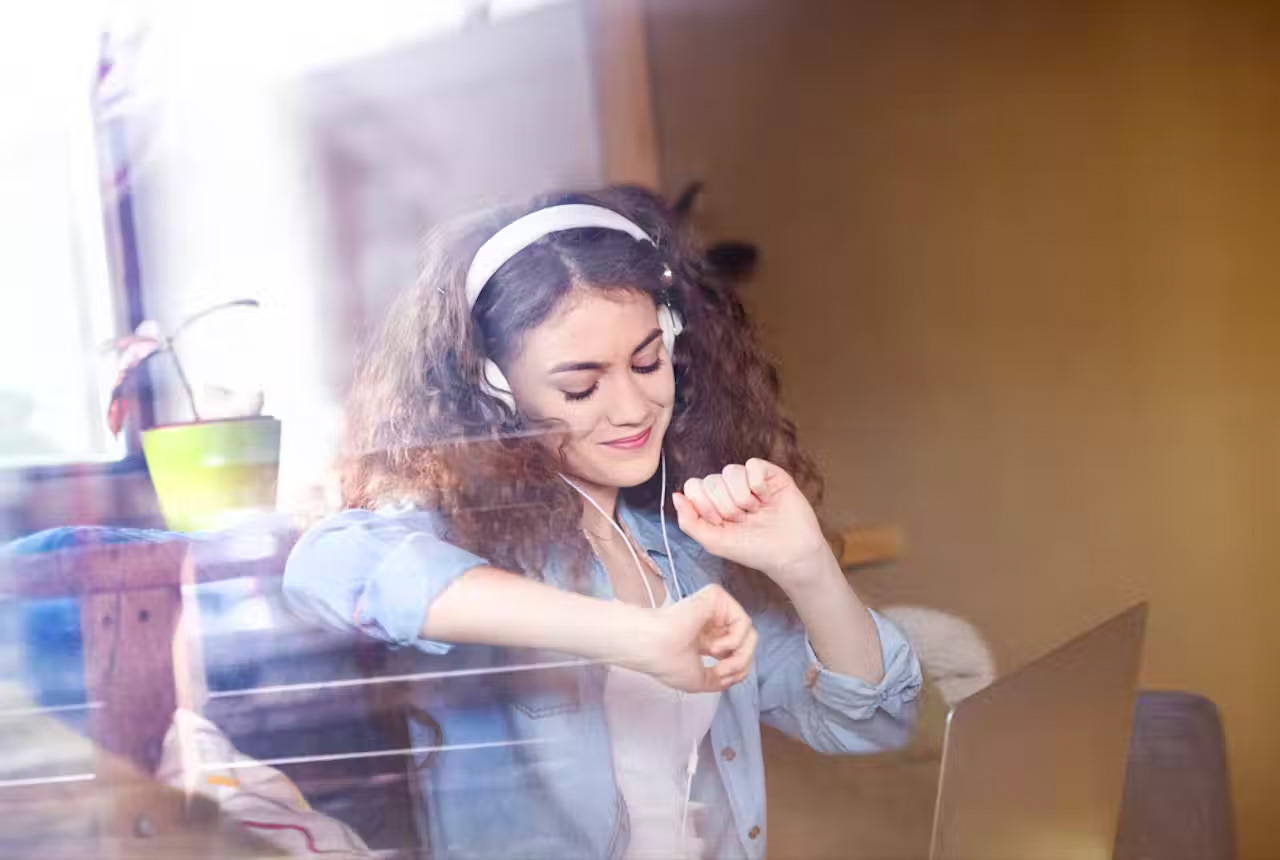 Young woman wearing headphones, dancing.