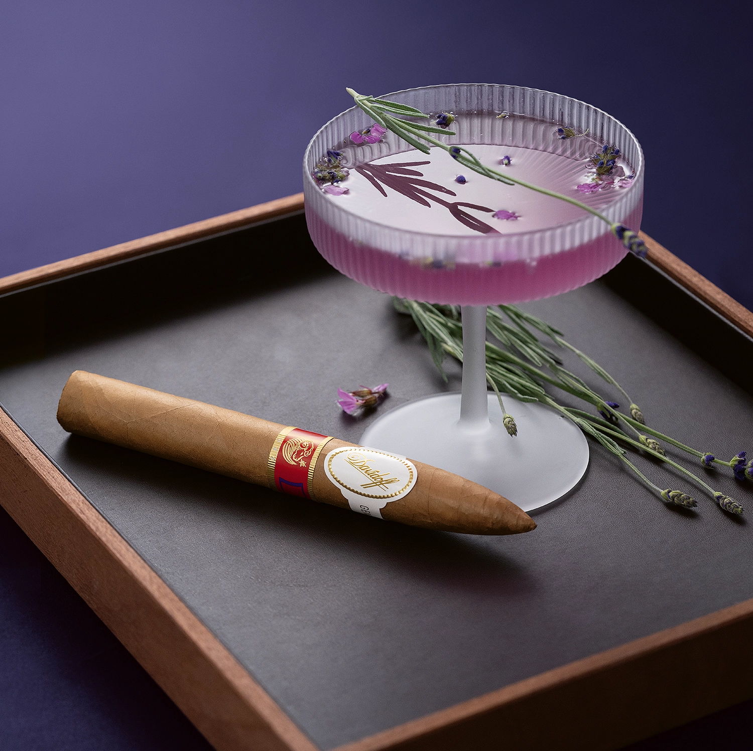 Die Year of the Sheep-Piramides-Zigarre neben einem Purple Gin Cocktail.