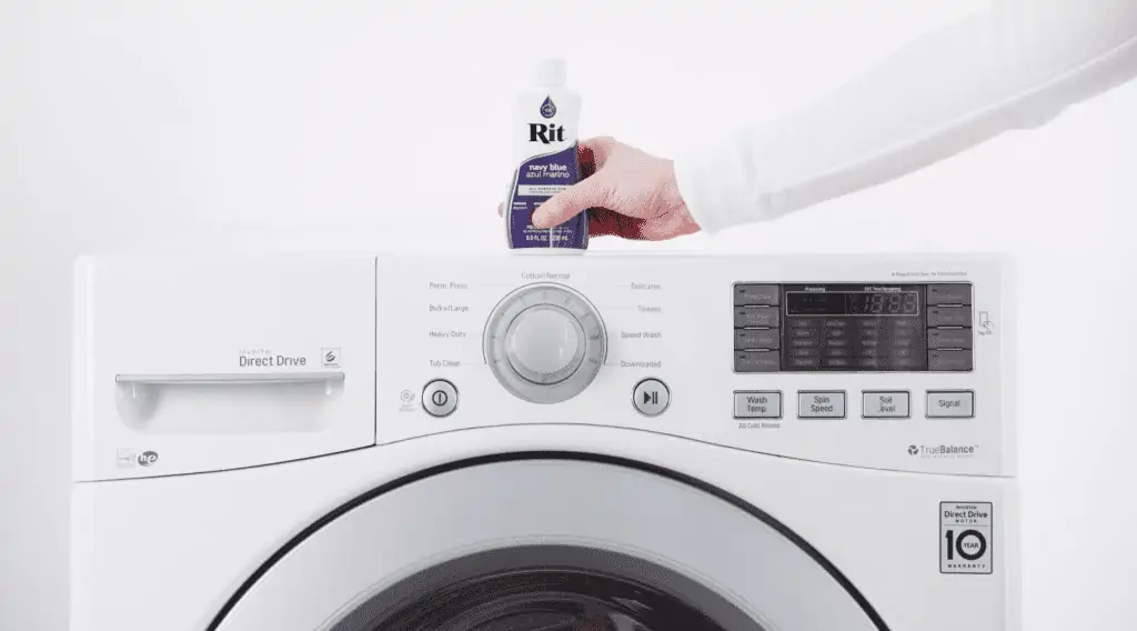 Person placing detergent on top of a washing machine.