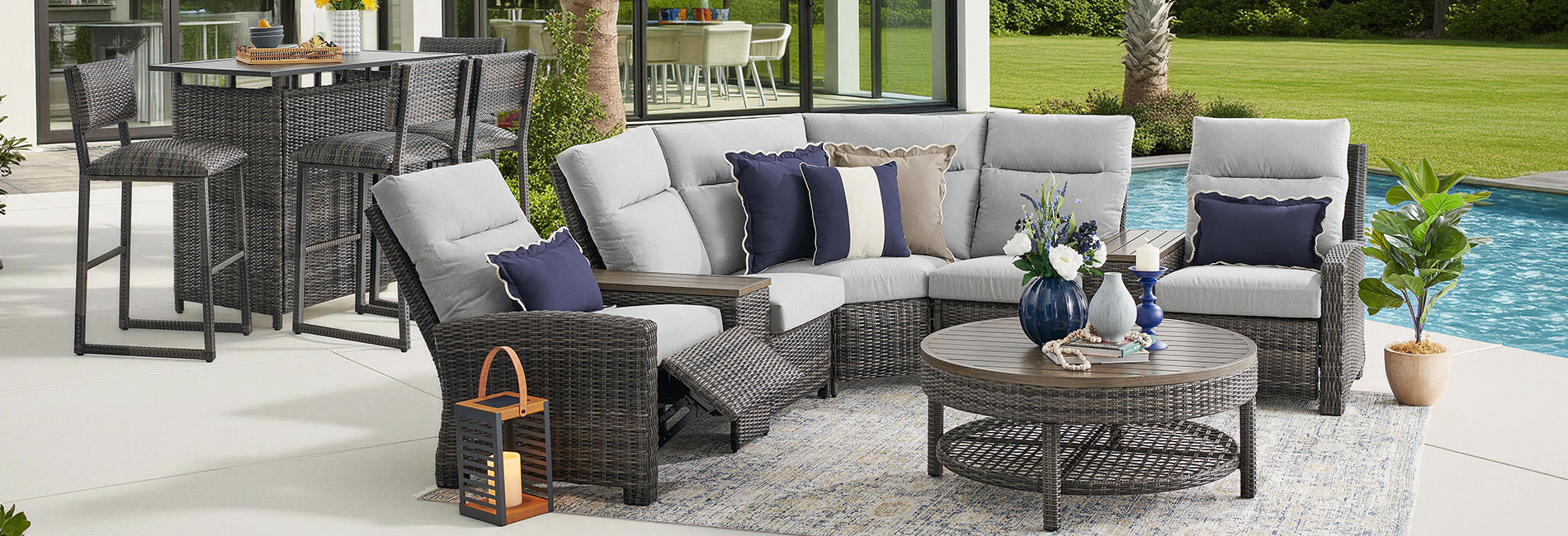 Outdoor seating area with sectional sofa, coffee table, and poolside view.